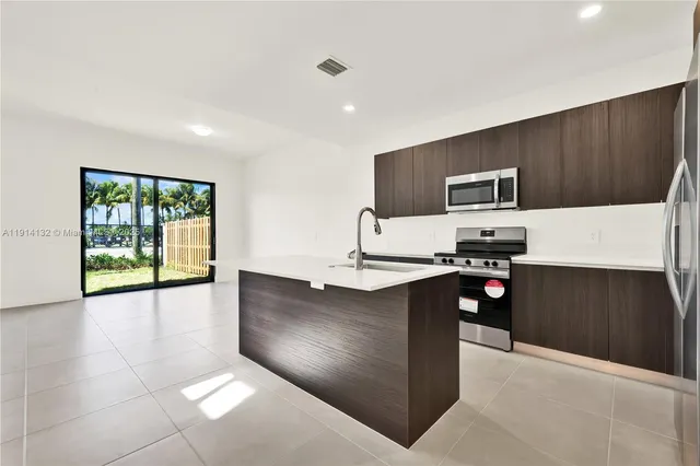 a kitchen with stainless steel appliances a stove sink and cabinets