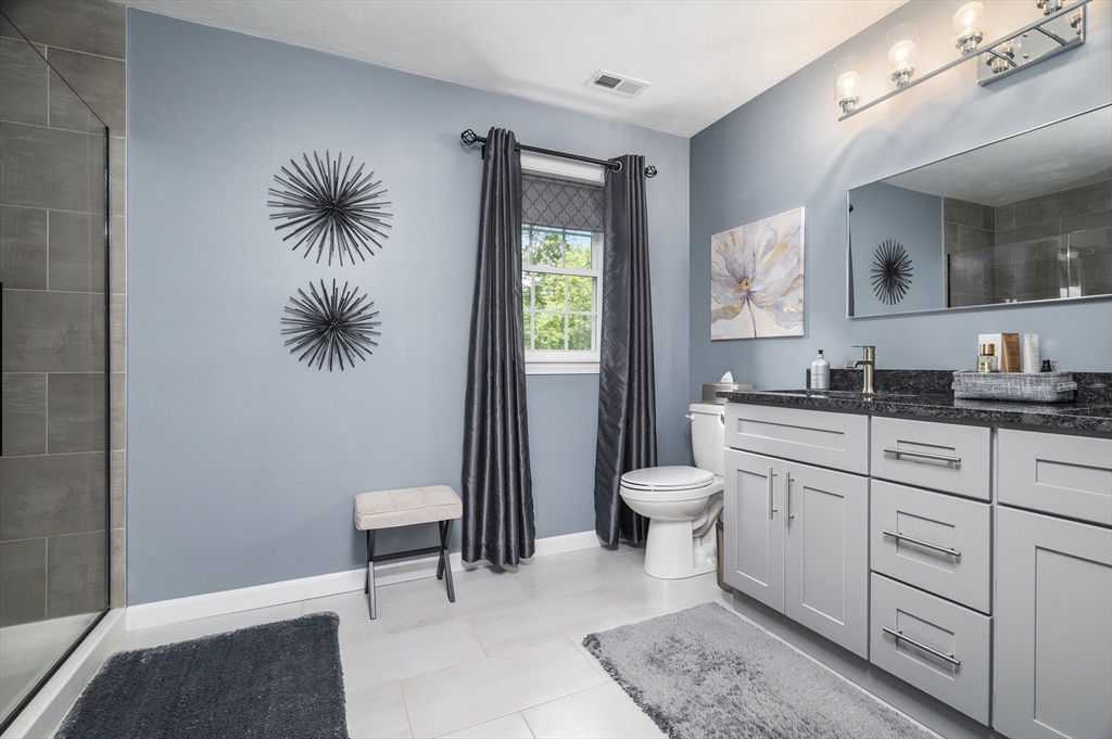 16 Farnum Street, Unit 16 Uxbridge, MA 01569 - Photo 20 of 34 a spacious bathroom with a toilet a sink and mirror