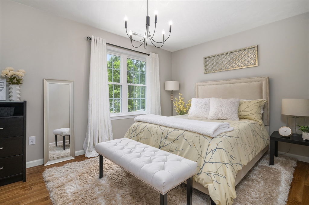 16 Farnum Street, Unit 16 Uxbridge, MA 01569 - Photo 23 of 34 a bedroom with a bed and wooden floor