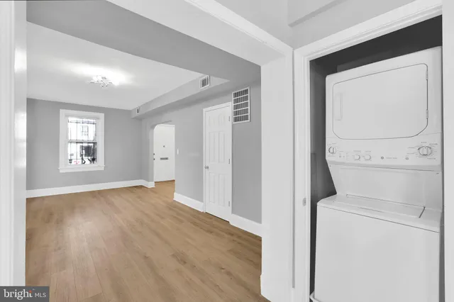 a view of empty room with window and wooden floor