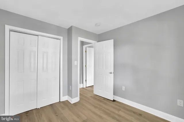 an empty room with wooden floor and closet