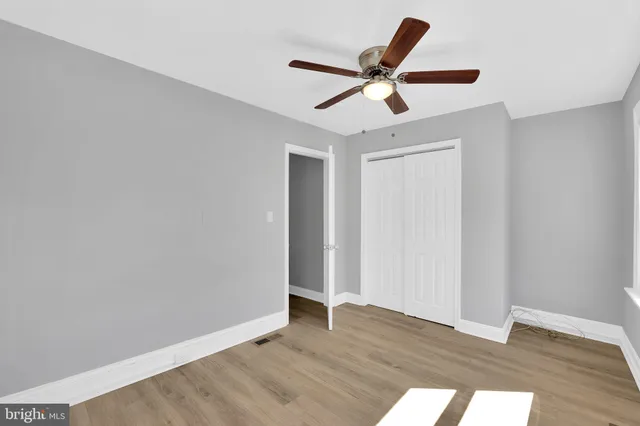 a view of room with wooden floor and ceiling fan