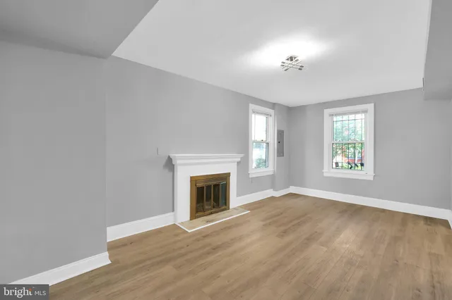 an empty room with windows and fireplace