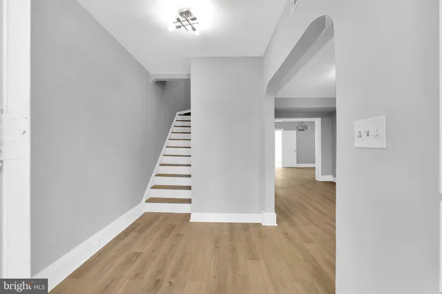 a view of a hallway with wooden floor and staircase
