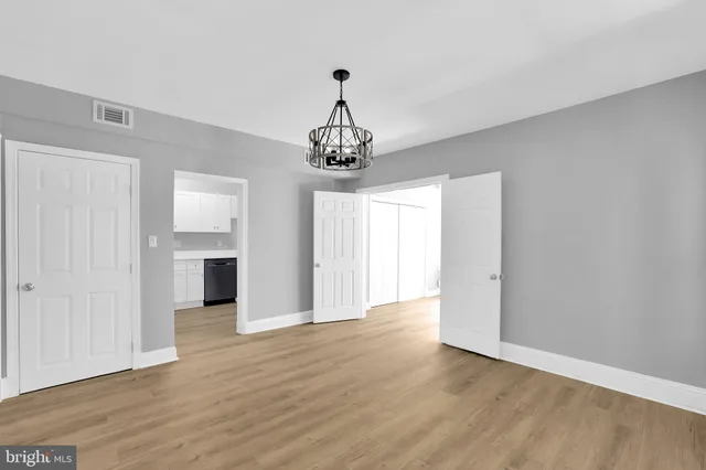a view of a room with wooden floor closet and windows