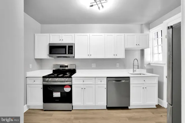 a kitchen with stainless steel appliances a sink stove and refrigerator