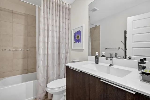 a bathroom with a double vanity sink toilet and shower