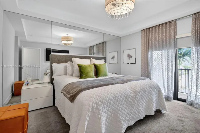 a bedroom with a balcony a bed and a chandelier