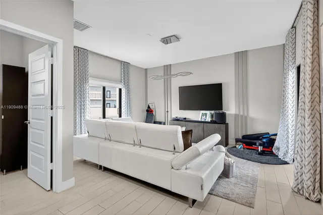 a living room with furniture a flat screen tv and a wall painting