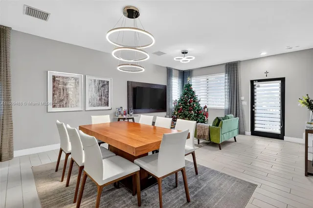 a kitchen with stainless steel appliances granite countertop a sink a stove a refrigerator cabinets and chairs