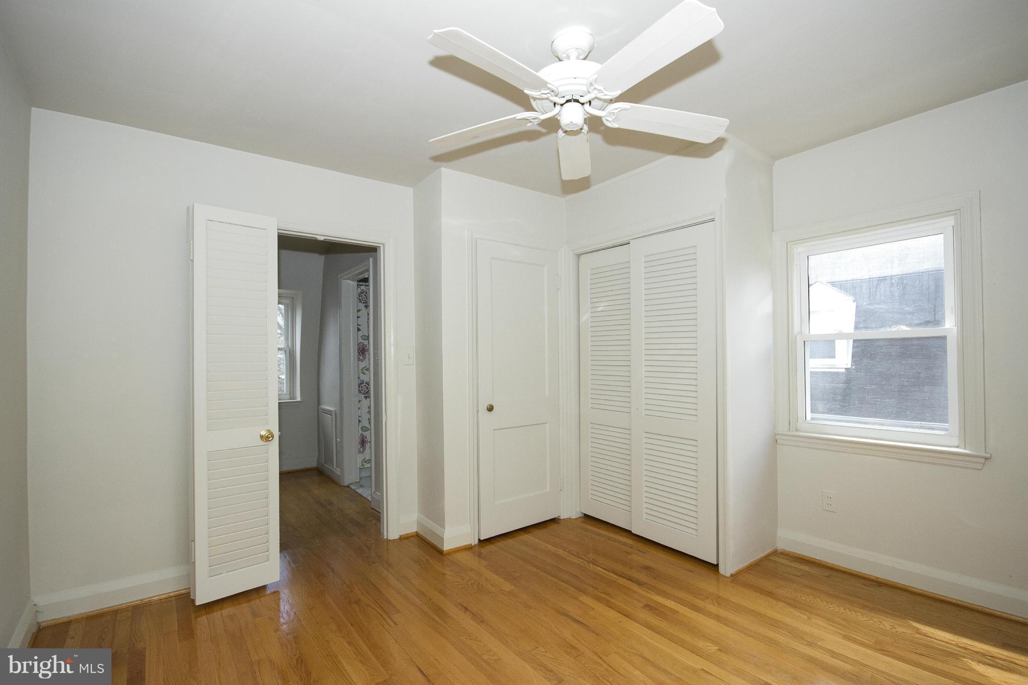 2504 Wetherburn Road Baltimore, MD 21209 - Photo 8 of 17 an empty room with wooden floor and ceiling fan