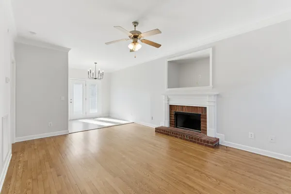 wooden floor fireplace and windows in an empty room