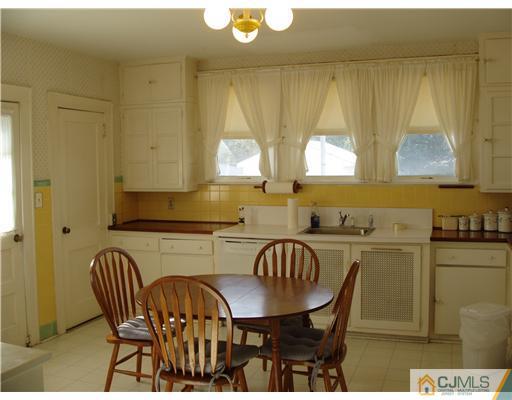 145 Rector Street Perth Amboy, NJ 08861 - Photo 4 of 17 a kitchen with a table chairs sink and cabinets