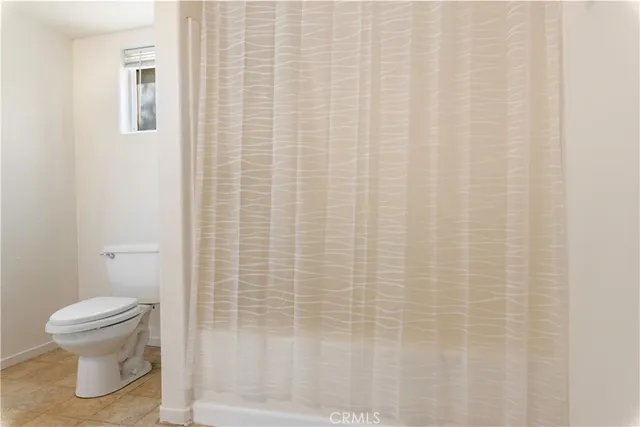 a bathroom with a toilet and a shower curtain