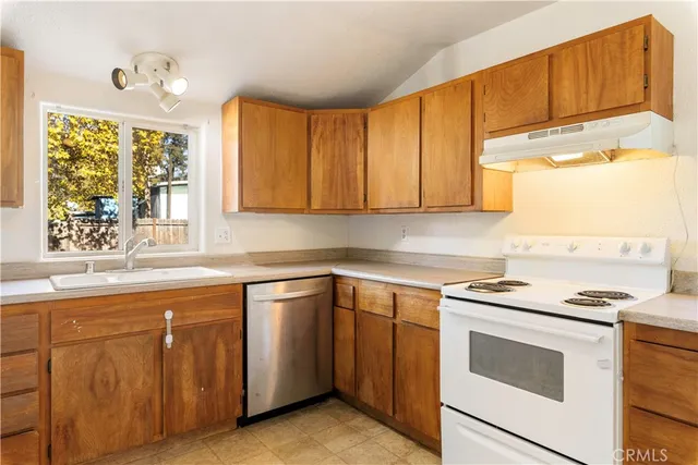 a kitchen with cabinets appliances a sink and a window