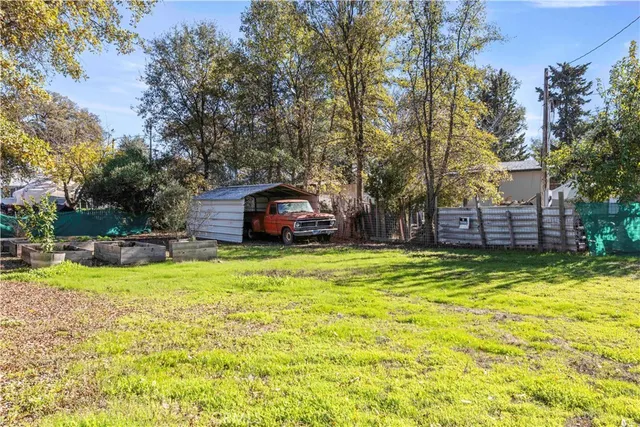 a tall yellow house with a yard