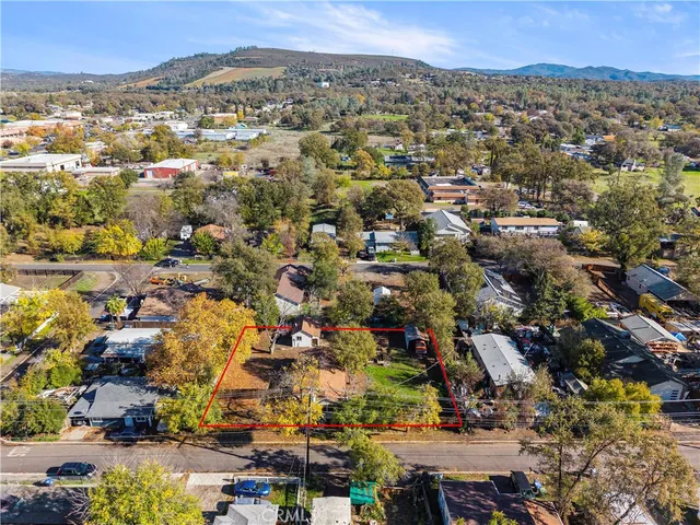 an aerial view of residential houses with outdoor space and trees