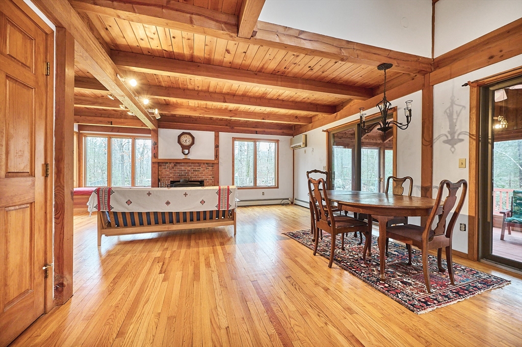 130 Coles Meadow Road Northampton, MA 01060 - Photo 6 of 42 a dining room with wooden floor a chandelier a wooden table and chairs