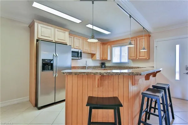a kitchen with stainless steel appliances granite countertop a refrigerator and a stove