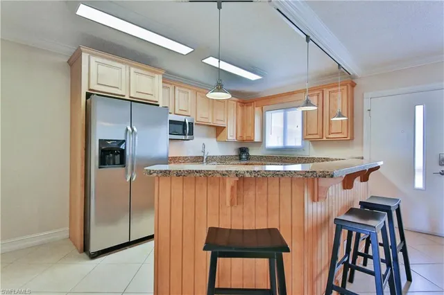 a kitchen with stainless steel appliances granite countertop a refrigerator and a stove