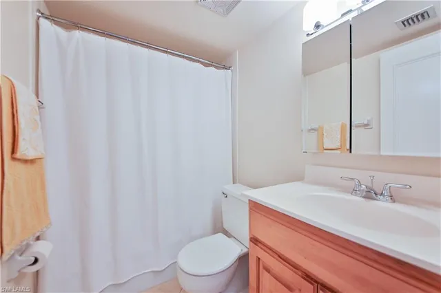 a bathroom with a sink a toilet and shower curtain