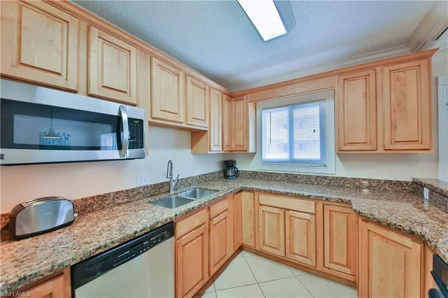 a kitchen with granite countertop stainless steel appliances sink microwave and stove