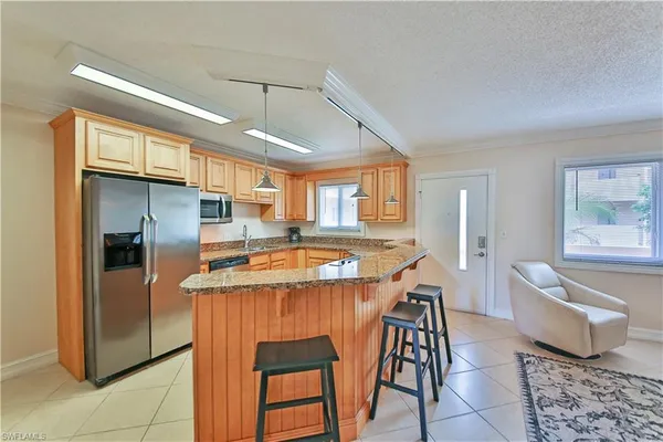 a kitchen with stainless steel appliances granite countertop a sink and a refrigerator