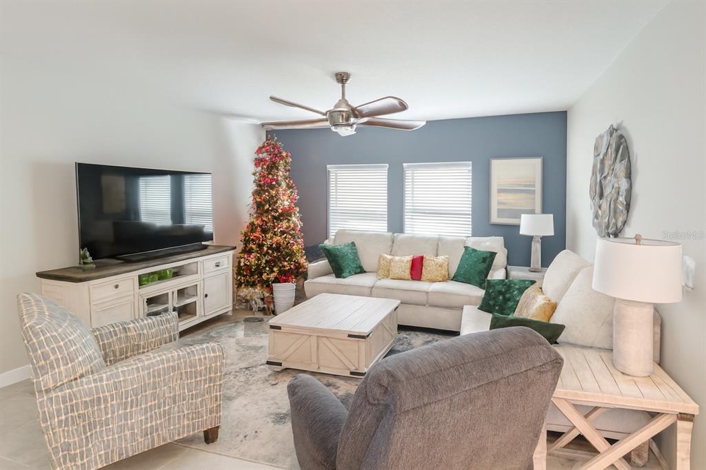 9611 Rampart Road Leesburg, FL 34788 - Photo 6 of 24 a living room with furniture a flat screen tv and a chandelier