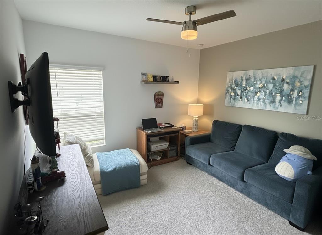 9611 Rampart Road Leesburg, FL 34788 - Photo 10 of 24 a living room with furniture and a flat screen tv