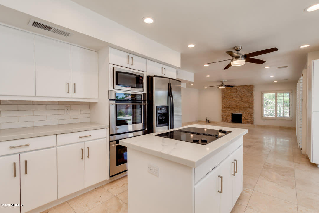 7475 East Raintree Court Scottsdale, AZ 85258 - Photo 1 of 38 a kitchen that has a cabinets and a stove with wooden floor