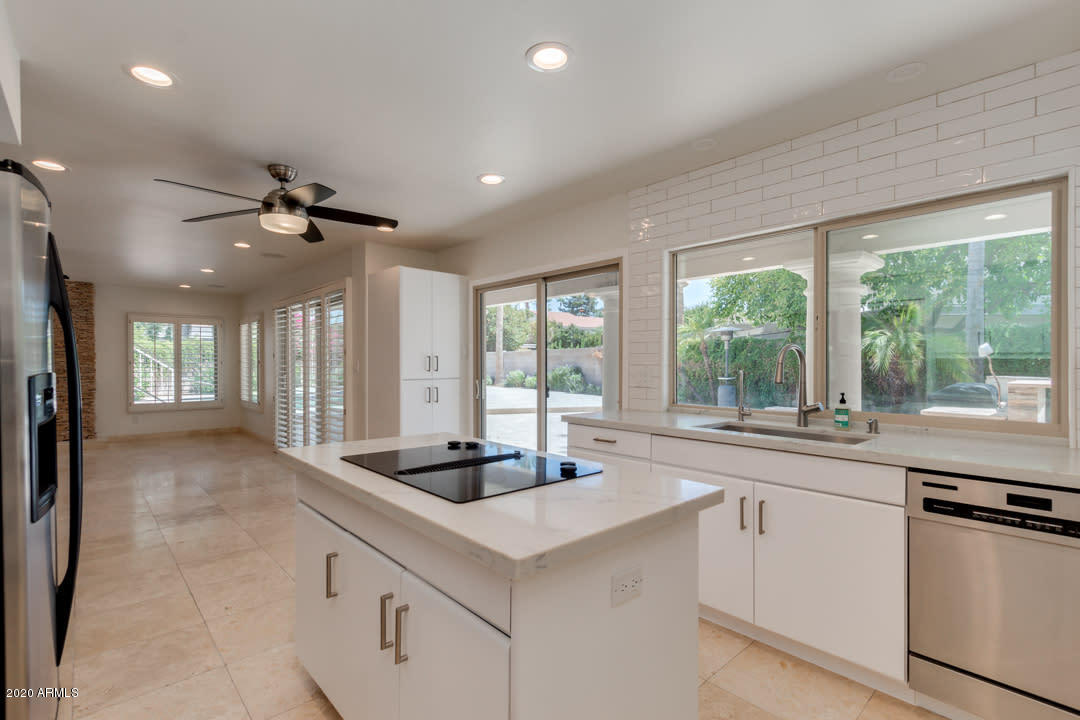 7475 East Raintree Court Scottsdale, AZ 85258 - Photo 11 of 38 a kitchen with granite countertop a sink appliances cabinets and a large window