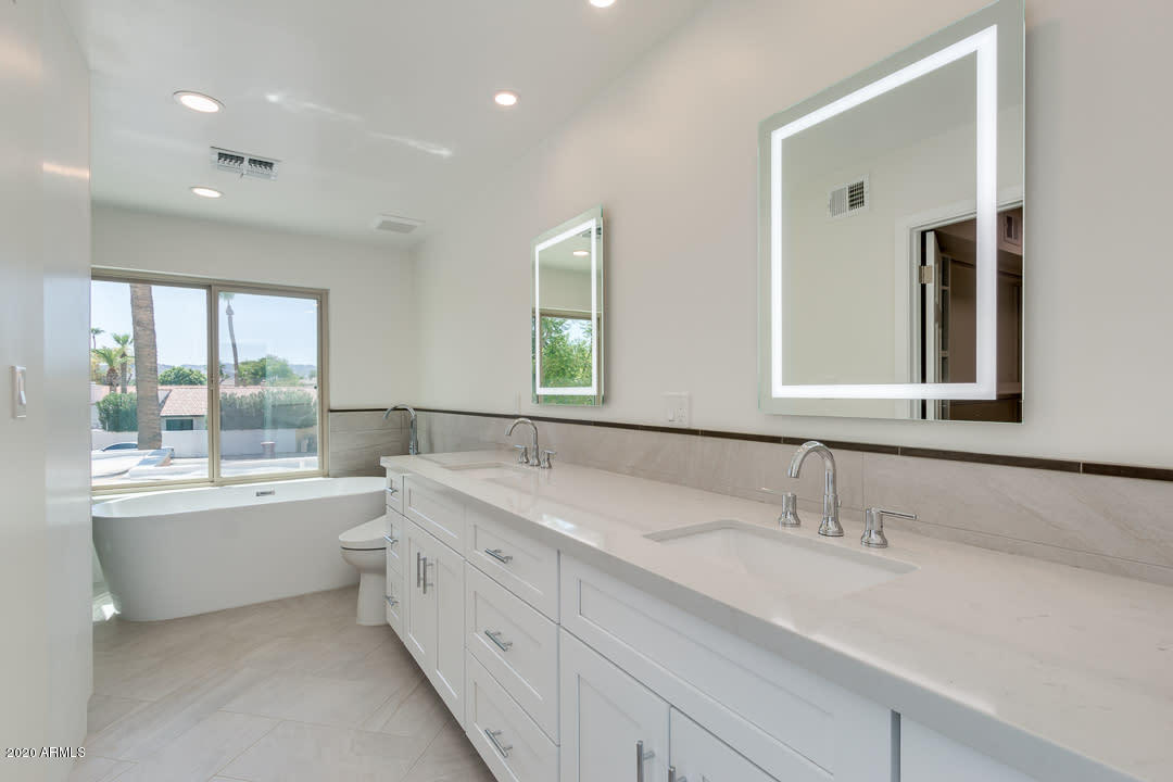 7475 East Raintree Court Scottsdale, AZ 85258 - Photo 15 of 38 a bathroom with a granite countertop sink mirror bathtub and toilet