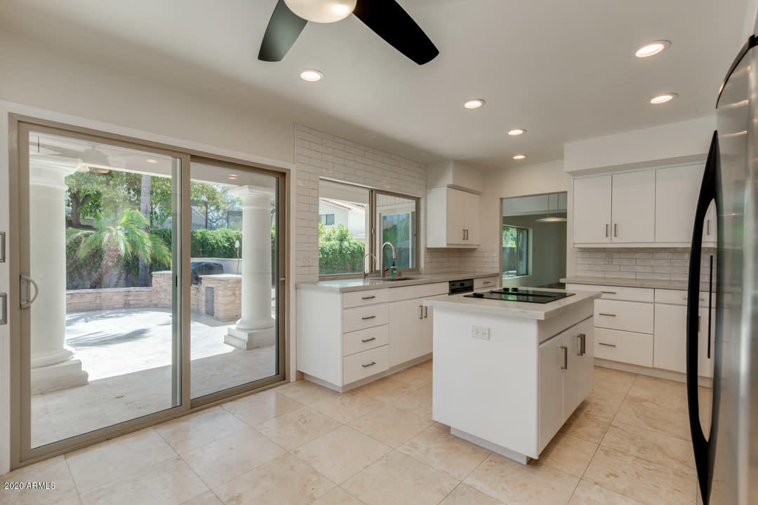 7475 East Raintree Court Scottsdale, AZ 85258 - Photo 10 of 38 a kitchen with white cabinets and white appliances