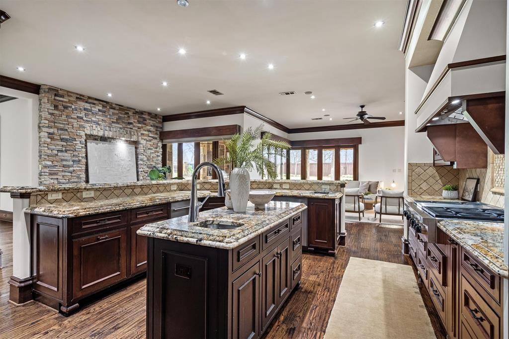 9 Victory Lane Double Oak, TX 75077 - Photo 11 of 40 Chef’s kitchen designed as the heart of the home with granite countertops, professional-grade appliances, and abundant custom cabinetry. The oversized island offers generous prep space and room for gathering.