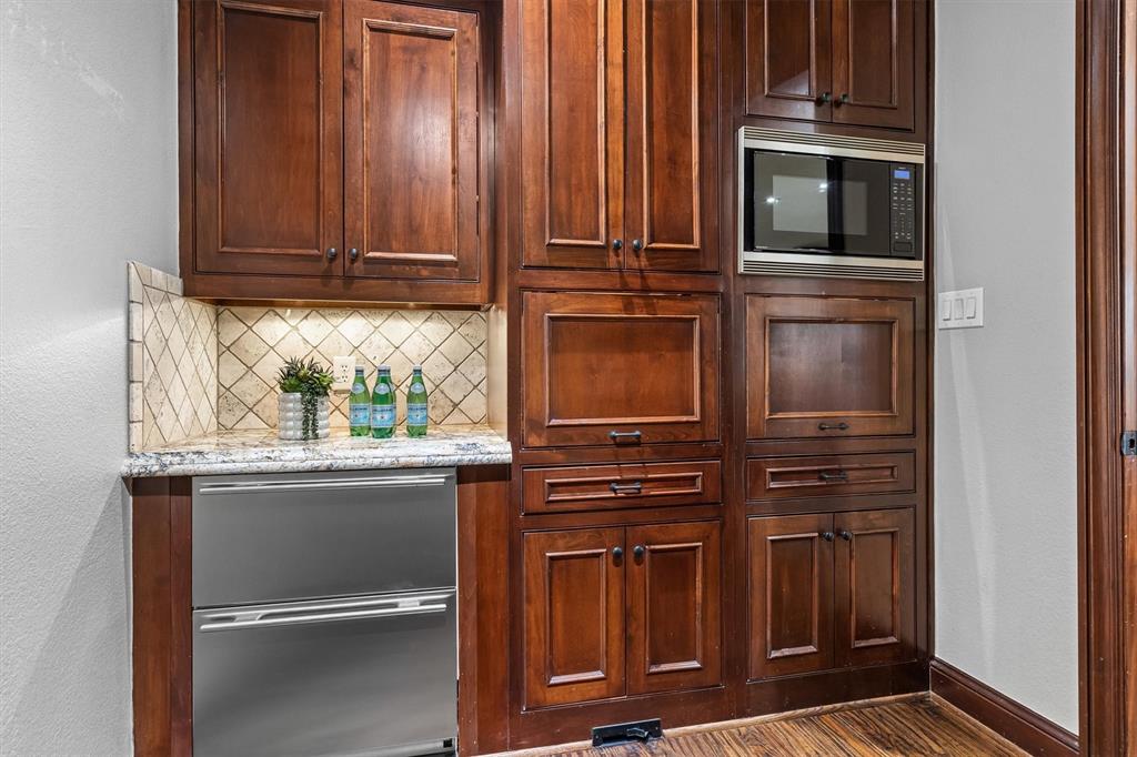 9 Victory Lane Double Oak, TX 75077 - Photo 14 of 40 Custom built-in coffee and beverage station adds convenience and elegance to the kitchen space. Ideal for morning routines or serving guests during gatherings.
