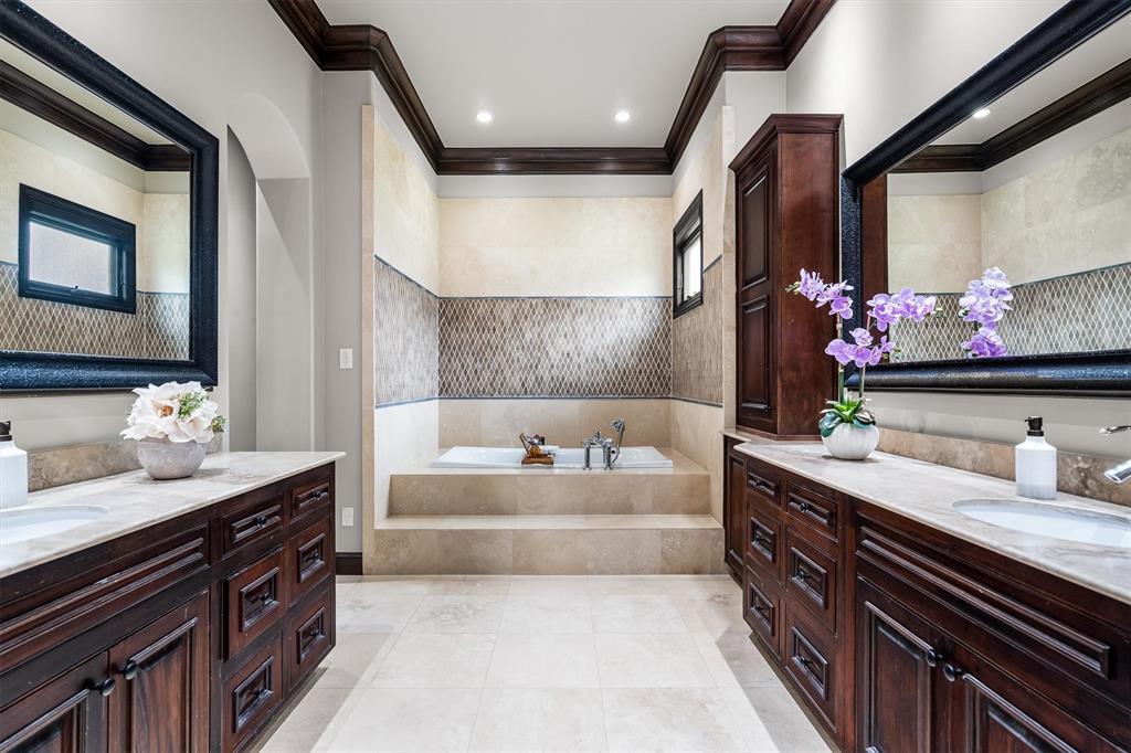 9 Victory Lane Double Oak, TX 75077 - Photo 20 of 40 Spa-inspired primary bathroom featuring dual vanities, custom cabinetry, and a spacious layout. Designed for both luxury and functionality with abundant storage.