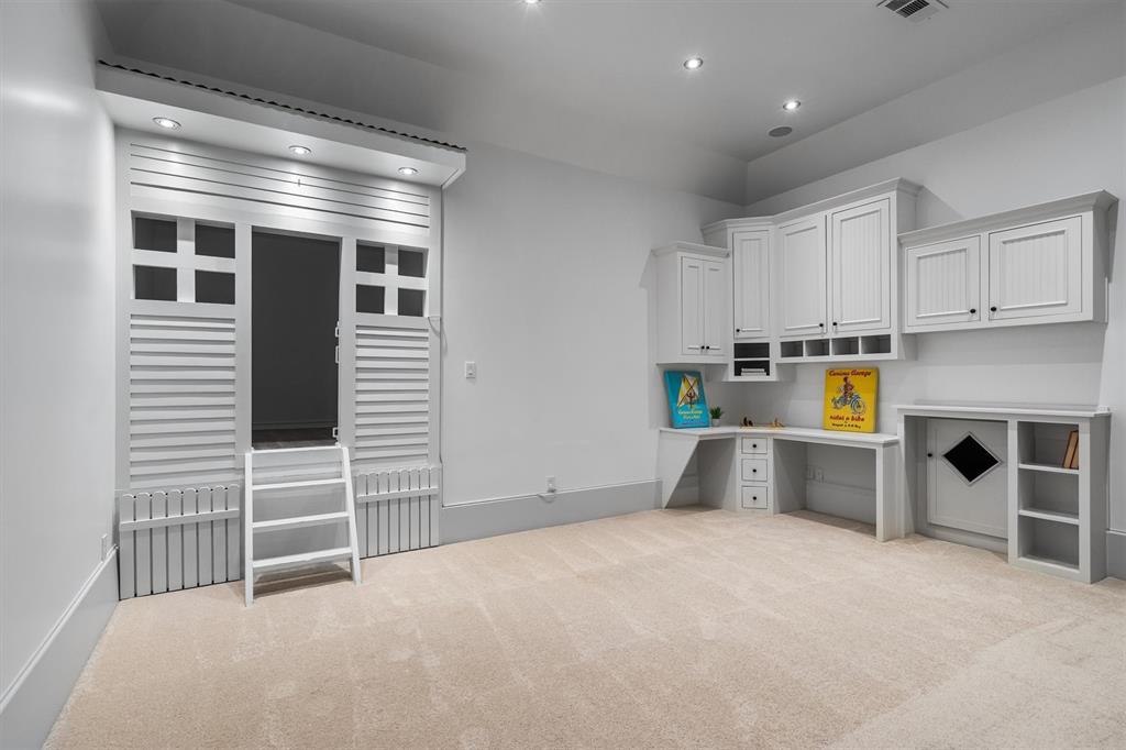 9 Victory Lane Double Oak, TX 75077 - Photo 24 of 40 A thoughtfully designed playroom that blends creativity and organization, featuring custom built-in cabinetry, a workspace for crafts or homework, and charming playhouse-style shutters with ladder access for imaginative fun. Bright, open, and versatile, this space is perfect for playtime, learning, and keeping everything neatly tucked away.