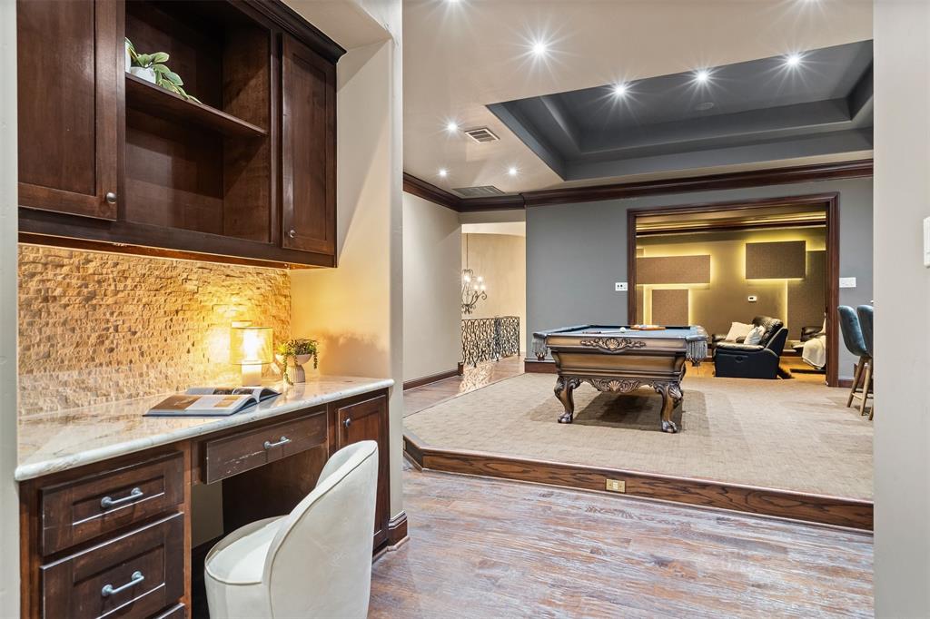 9 Victory Lane Double Oak, TX 75077 - Photo 31 of 40 Entertaining lounge and bar area designed for hosting friends and family. Custom cabinetry, warm lighting, and stone accents create a sophisticated atmosphere for gatherings.