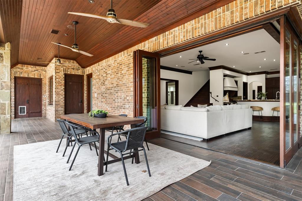 9 Victory Lane Double Oak, TX 75077 - Photo 34 of 40 Expansive covered outdoor living area featuring a wood-paneled ceiling, fireplace, and comfortable seating space. Ideal for relaxing or entertaining while enjoying views of the backyard and pool.