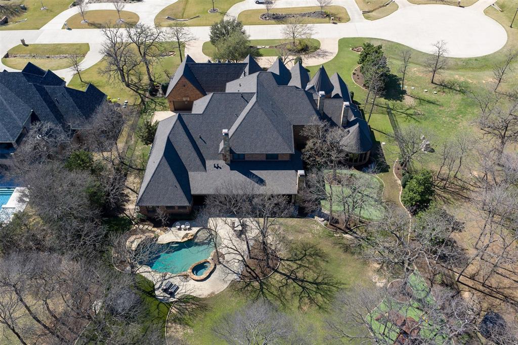 9 Victory Lane Double Oak, TX 75077 - Photo 39 of 40 Aerial view highlights the impressive scale of the estate set across two treed acres. The home’s layout, outdoor amenities, and surrounding privacy are clearly showcased from above.