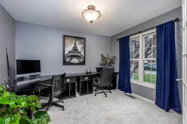 a view of a livingroom with workspace and a window