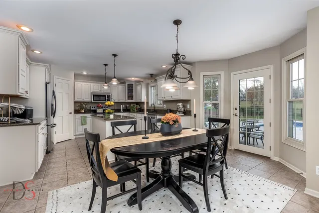 a view of a dining room and livingroom with furniture wooden floor a chandelier