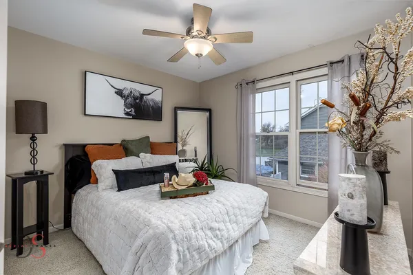 a bedroom with a bed and a lamp on dresser