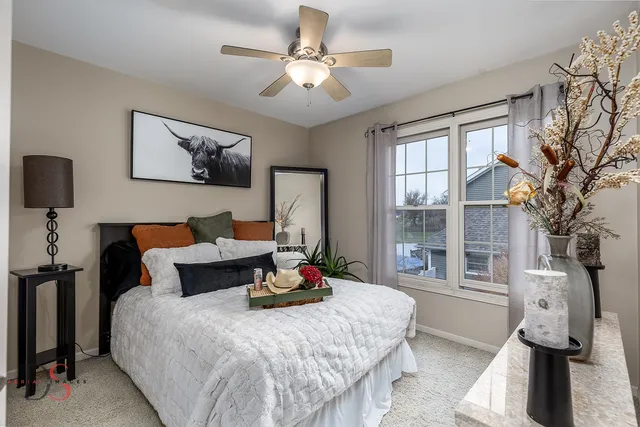 a bedroom with a bed and a lamp on dresser