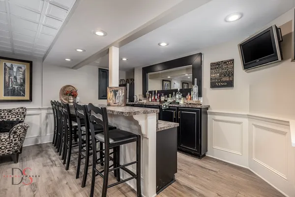 a kitchen with stainless steel appliances granite countertop a table and chairs in it