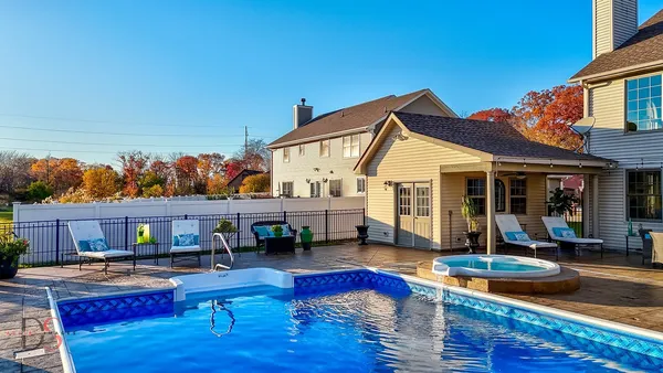 a view of house with swimming pool outdoor seating