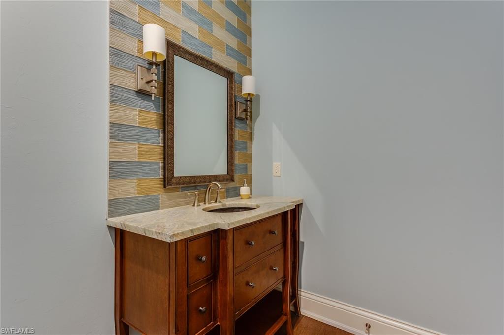 6578 Ridgewood Drive Naples, FL 34108 - Photo 11 of 35 a bathroom with a sink and a mirror