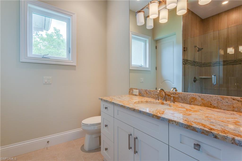 6578 Ridgewood Drive Naples, FL 34108 - Photo 26 of 35 a bathroom with a granite countertop sink mirror and toilet