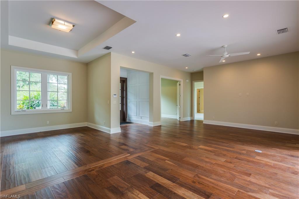 6578 Ridgewood Drive Naples, FL 34108 - Photo 7 of 35 a view of an empty room with wooden floor and a window