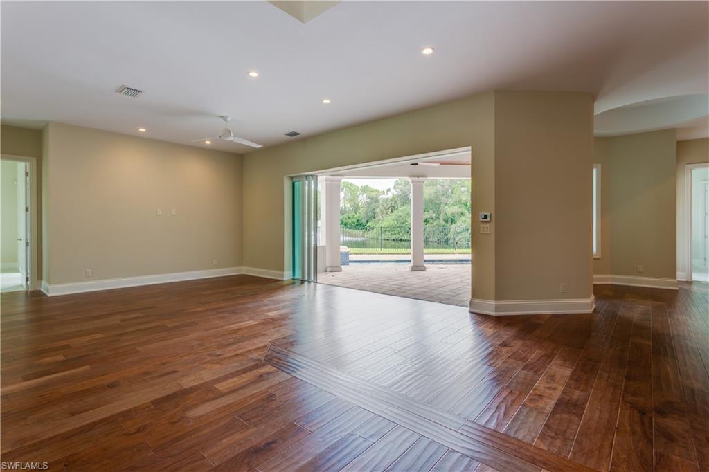 6578 Ridgewood Drive Naples, FL 34108 - Photo 8 of 35 a view of an empty room with wooden floor and a window